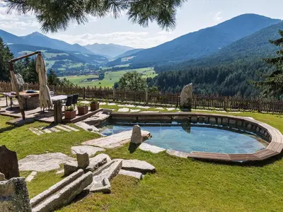 a backyard with a pool and mountains in the background at Chalet Piz da Peres in Valdaora