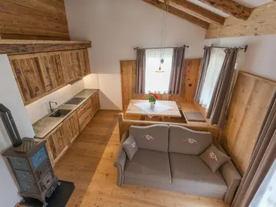 a dining room with a table and chairs and wooden walls at Chalet Piz da Peres in Valdaora