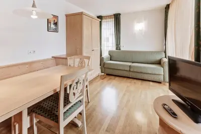 a living room with a table and a couch at Apartments Petlin in Ortisei