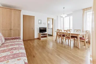 a living room with a table and a dining room at Apartments Petlin in Ortisei