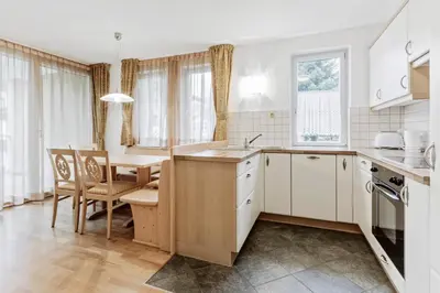a kitchen with a table and a dining room at Apartments Petlin in Ortisei