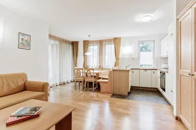 a kitchen and living room with a couch and a table at Apartments Petlin in Ortisei