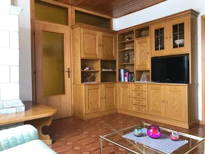 a living room with wooden cabinets and a tv at Appartamento Pezzol in Daiano