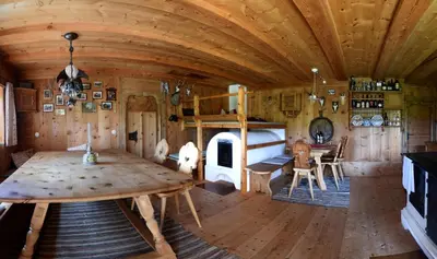 a room with a table and a bed in a cabin at Hotel Garni Vanadis in Ortisei