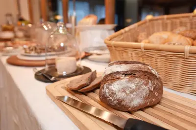 a loaf of bread on a cutting board with a knife at Hotel Garni Vanadis in Ortisei