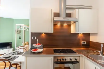 a kitchen with white cabinets and a stove top oven at Apartment Maximilian in Merano