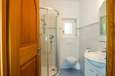 a bathroom with a shower and a toilet and a sink at Gästehaus Seitzhof in Merano