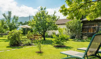 a garden with a bench and tables and trees at Gästehaus Seitzhof in Merano