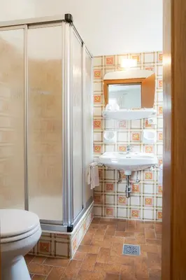 a bathroom with a shower and a toilet and a sink at Gästehaus Seitzhof in Merano