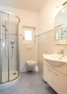 a bathroom with a shower and a toilet and a sink at Gästehaus Seitzhof in Merano
