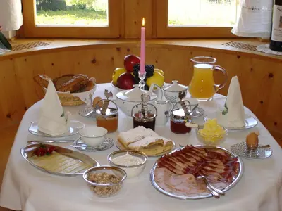 a table with a buffet of breakfast food on it at Gästehaus Seitzhof in Merano