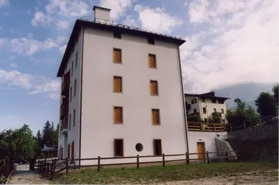 a large white building with a fence around it at Casa bianca in San Vito di Cadore