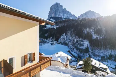 a building with a view of a snow covered mountain at Hotel Ciamp in Santa Cristina in Val Gardena