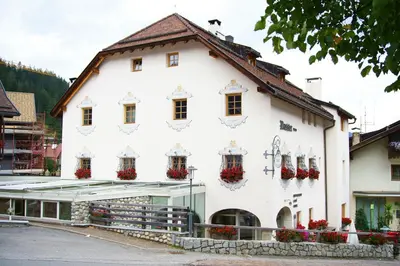 a white building with flowers on the windows at Gasthof/Albergo Dasser in San Martino in Badia
