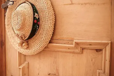 a straw hat is hanging on a wooden door at Gasthof/Albergo Dasser in San Martino in Badia