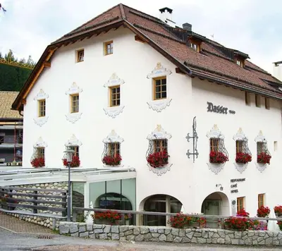 a white building with flowers on the side of it at Gasthof/Albergo Dasser in San Martino in Badia