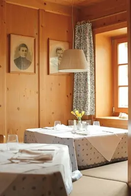 a dining room with two tables and a window at Gasthof/Albergo Dasser in San Martino in Badia