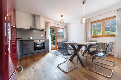 a kitchen with a table and chairs in a room at Panoramic Apartment 24 in Ortisei