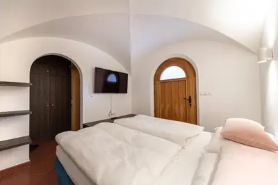 a bedroom with two beds and a tv on the wall at Panoramic Apartment 24 in Ortisei