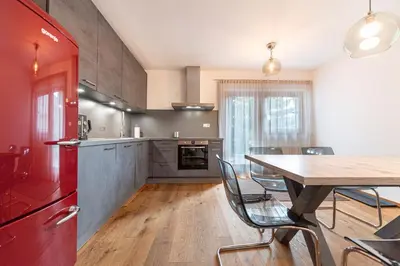 a kitchen with a table and a red refrigerator at Panoramic Apartment 24 in Ortisei