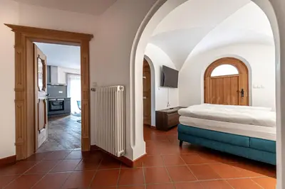 a bedroom with a bed and an arched doorway at Panoramic Apartment 24 in Ortisei