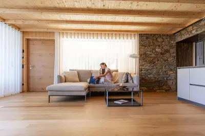 a woman sitting on a couch in a living room at Arua Private Spa Villas in Merano