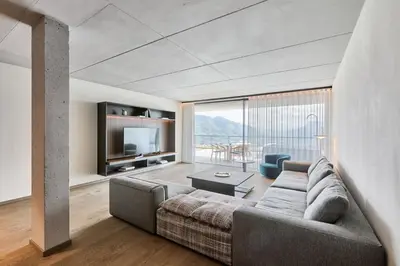 a living room with a couch and a television at Arua Private Spa Villas in Merano