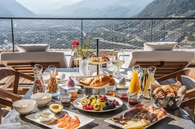 a table with food on it with a view of mountains at Arua Private Spa Villas in Merano
