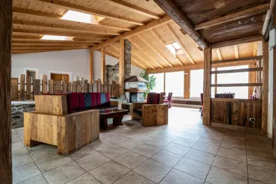 a large living room with wooden ceilings and wooden furniture at Gruberhof Coll in Funes