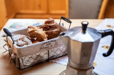 a basket of pastries sitting next to a blender on a table at Gruberhof Coll in Funes