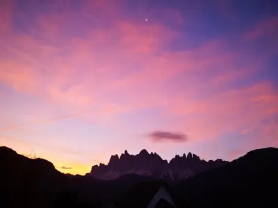 a sunset in the mountains with a red sky at Gruberhof Coll in Funes