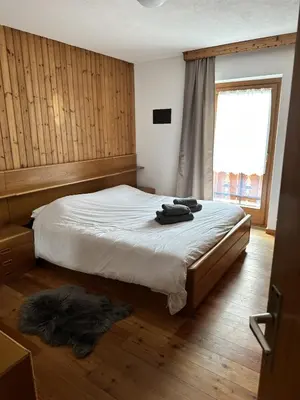 a bedroom with a bed and a window at ciasa de epi in Pera