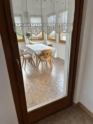 a table and chairs in a room with a window at ciasa de epi in Pera