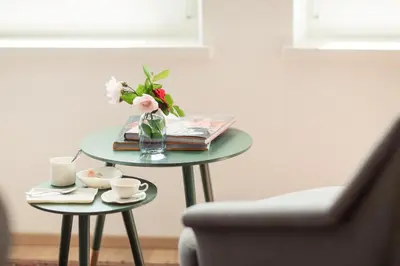 a table with a vase of flowers and books at Residence Belmonte in Collalbo