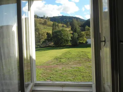a window with a view of a green field at CASA CAMPAGNA in Cavalese