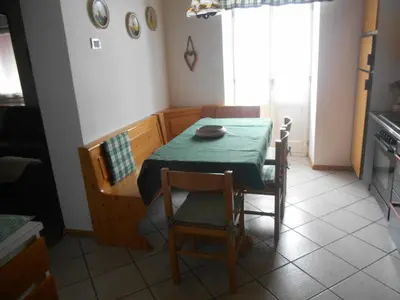 a dining room with a table and chairs and a kitchen at CASA CAMPAGNA in Cavalese
