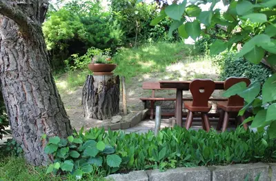 a picnic table and two chairs next to a tree at Oberjaistenhof in Lana