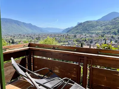 a chair sitting on a balcony with a view at Oberjaistenhof in Lana