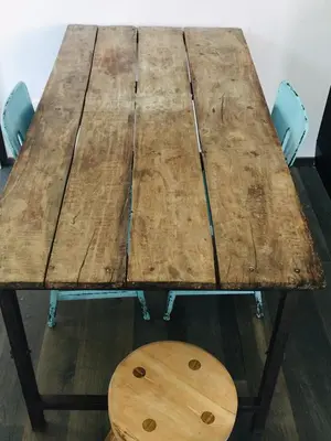 a wooden table with two chairs and a wooden stool at L'ECLECTIQUE Bolzano in Bolzano