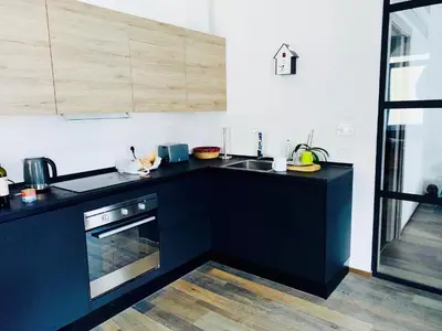 a kitchen with black counters and a sink and a stove at L'ECLECTIQUE Bolzano in Bolzano