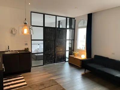 a living room with a couch and a large window at L'ECLECTIQUE Bolzano in Bolzano