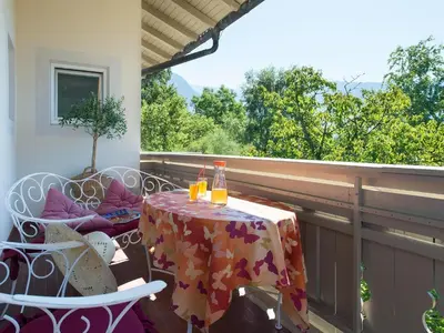 a table and chairs on a balcony with a table and drinks at Apartment in Dorf Tirol near Tirol Castle in Tirolo