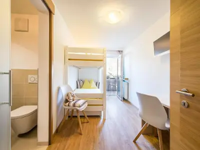 a small room with a bed and a desk and a chair at Apartment in Dorf Tirol near Tirol Castle in Tirolo