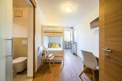 a small room with a bed and a desk and a chair at Apartment in Dorf Tirol near Tirol Castle in Tirolo