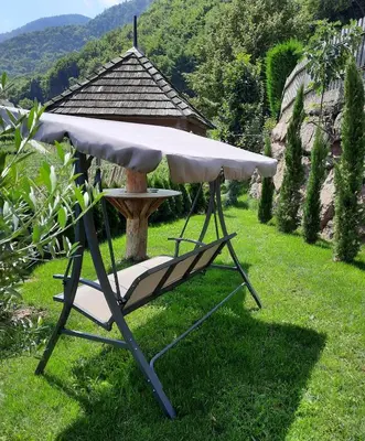 a table and a chair sitting in the grass at Bertoldihof in Cortaccia