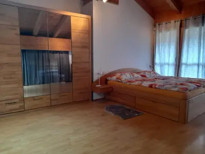 a bedroom with a bed and a glass shower at Bertoldihof in Cortaccia