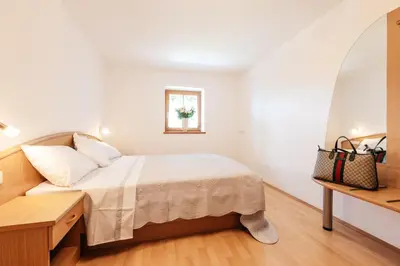 a small bedroom with a bed and a window at Bertoldihof in Cortaccia