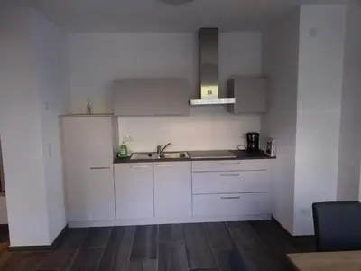 a kitchen with white cabinets and a sink at Pension Georgenhof in Cermes