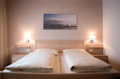 two beds in a bedroom with two lights on them at Pension Georgenhof in Cermes