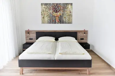 two beds in a bedroom with a painting on the wall at Pension Georgenhof in Cermes